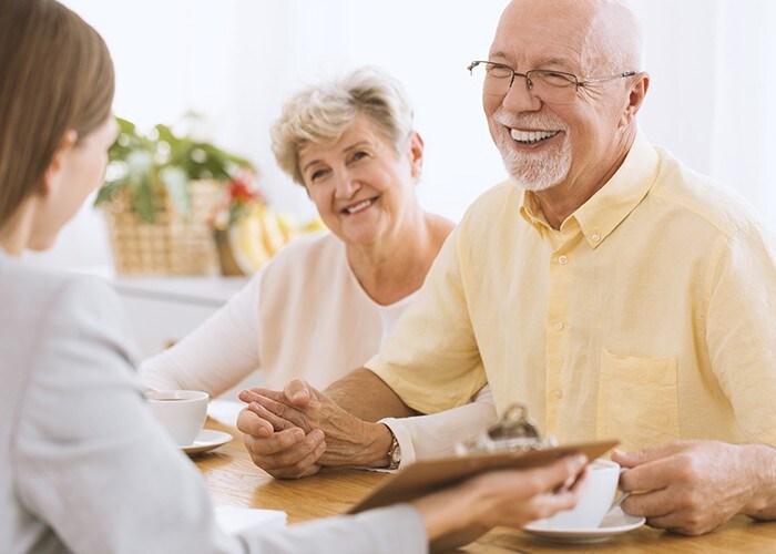 A smiling married elderly couple holding hands.
