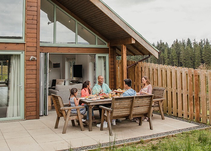 Famille prenant son déjeuner à l'extérieur du chalet.