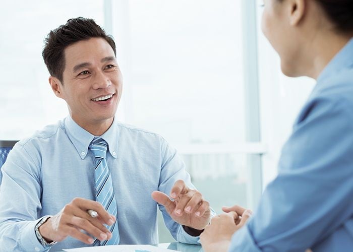 A wealth advisor and a client chatting in a boardroom.